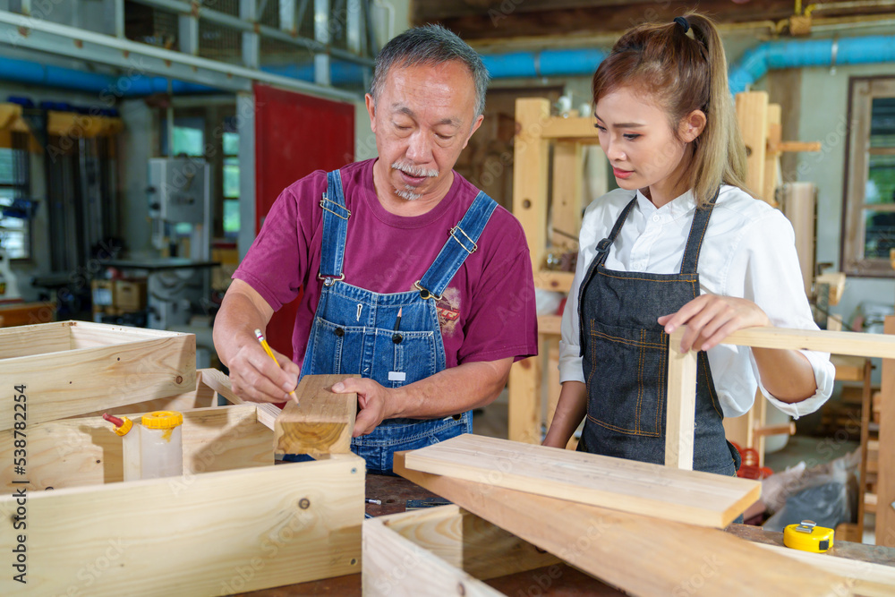 Teacher explaining a structure students while standing in a woodwork class Teacher explaining a structure students while standing in a woodwork class