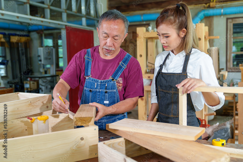 Teacher explaining a structure students while standing in a woodwork class Teacher explaining a structure students while standing in a woodwork class