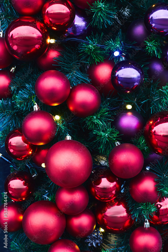 Colorful Christmas balls on a huge Christmas tree. The concept of a new year and Christmas. Vertical photo.