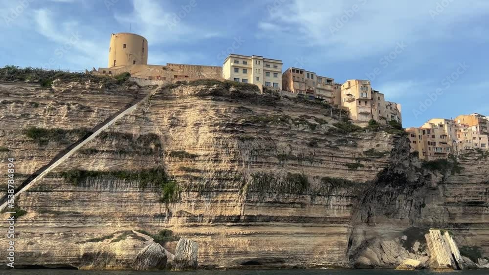 Low angle point of view of Bonifacio picturesque ancient Corsican city perched on edge of cliff of Corsica French island as seen from moving boat Low angle point of view of Bonifacio picturesque ancient Corsican city perched on edge of cliff of Corsica French island as seen from moving boat