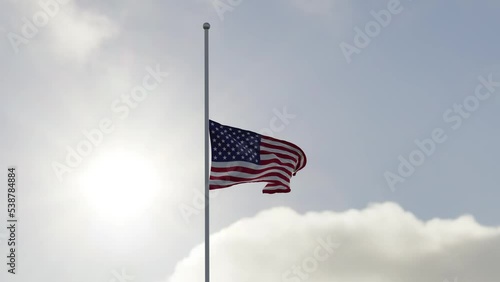 USA flag half mast in the wind. High bitrate slow motion animation in 4K. the Star-Spangled Banner and the sky. photo