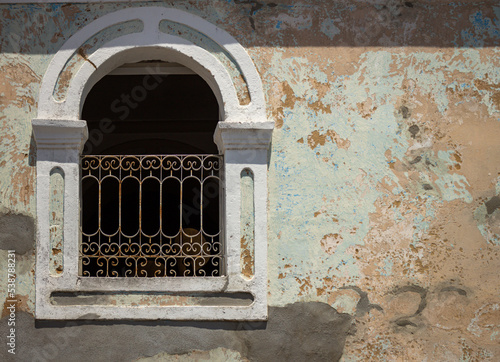 Old wall with a window and a grille. photo