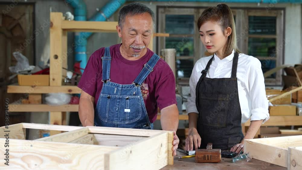 Tutor With Female Carpentry Student In Workshop Studying For Apprenticeship At College ,Teacher explaining a structure students while standing in a woodwork class Tutor With Female Carpentry Student In Workshop Studying For Apprenticeship At College ,Teacher explaining a structure students while standing in a woodwork class