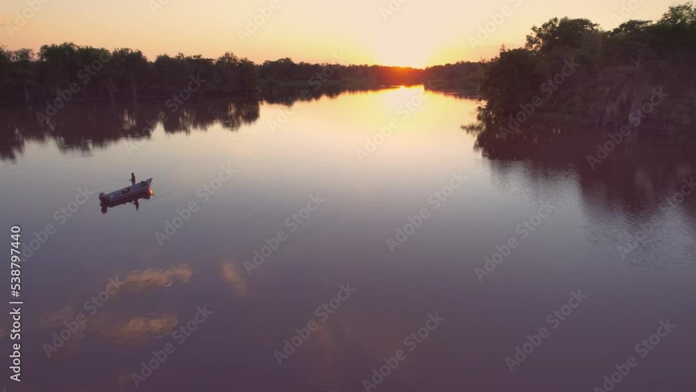 Louisiana swamp bay bayou cypress trees guy in boat fishing golden hour sunset steady shot Louisiana swamp bay bayou cypress trees guy in boat fishing golden hour sunset steady shot