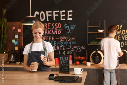 Young female barista with c...