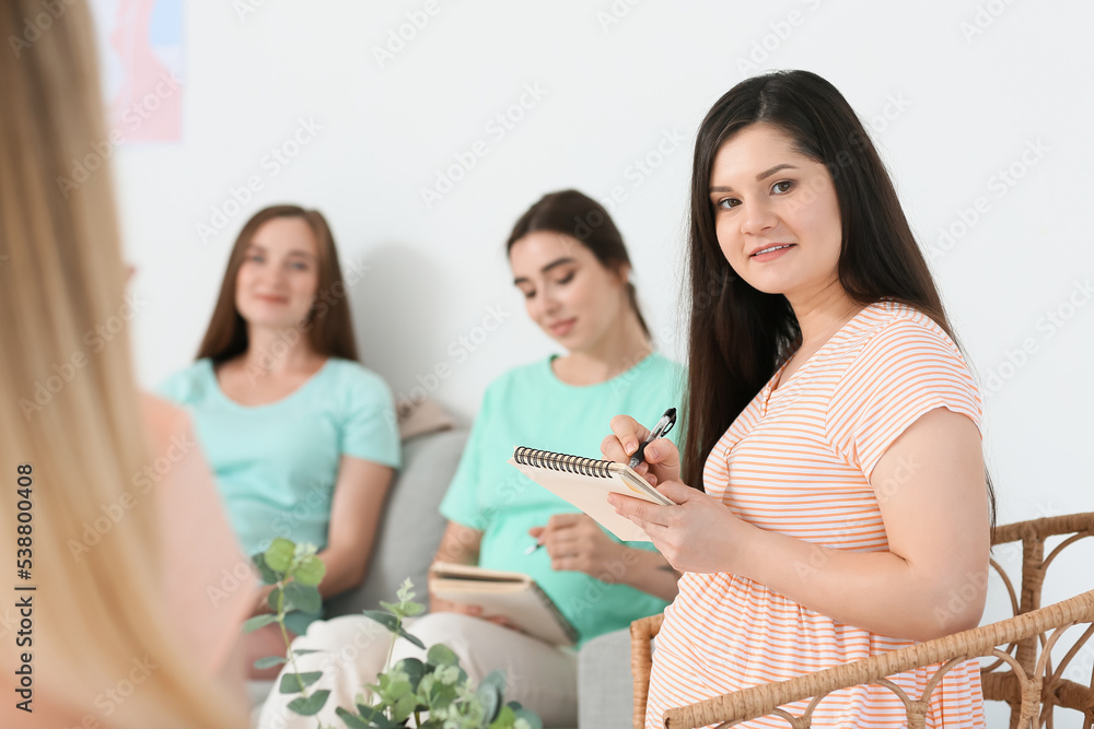 Young pregnant woman with notebook at course for expectant mothers Young pregnant woman with notebook at course for expectant mothers