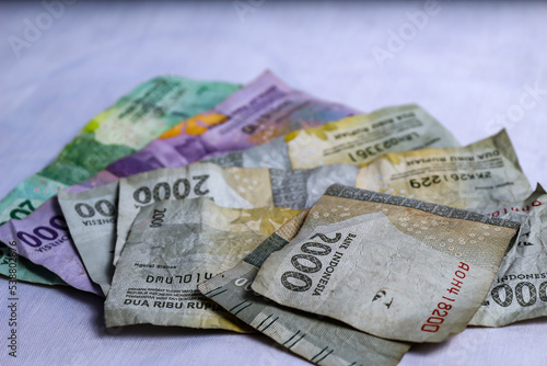 Indonesian rupiah banknotes, denominations of twenty thousand, ten thousand, two thousand and one thousand rupiah coins are overlapped in one frame. can be used as a background