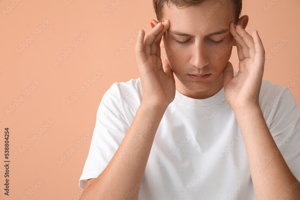 Stressed young man on beige background, closeup Stressed young man on beige background, closeup