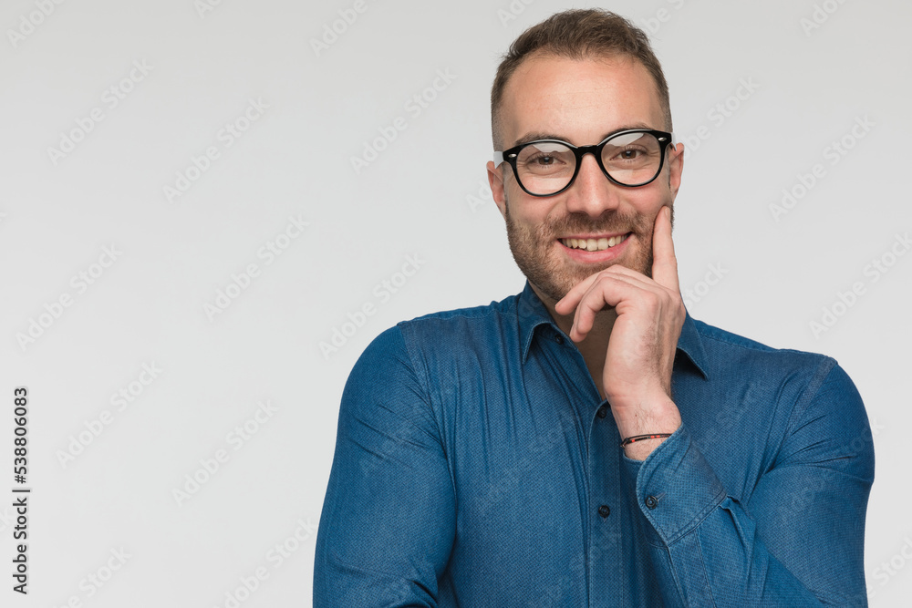 casual man is giving a cute smile at the camera casual man is giving a cute smile at the camera
