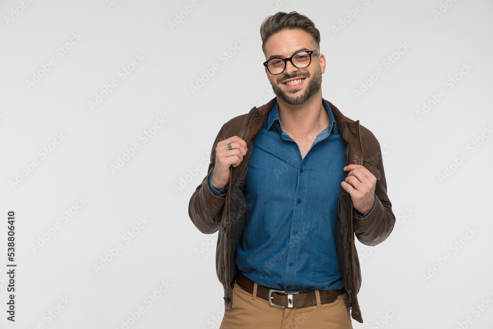 © Viorel Sima - enthusiatic young casual man in denim shirt smiling while adjusting jacket