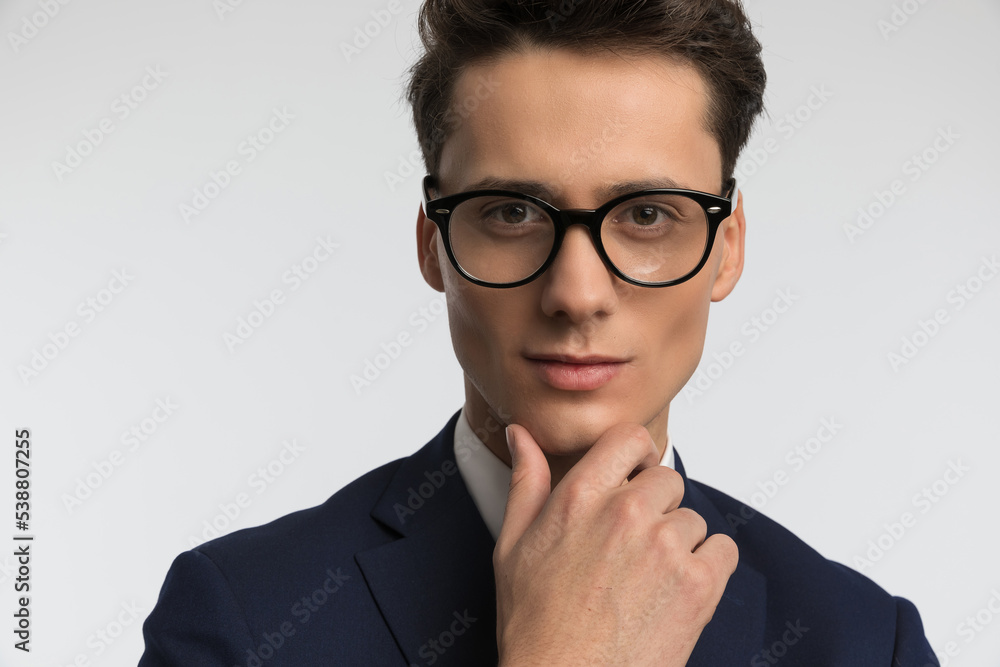 close up picture of pensive man with glasses touching chin and thinking close up picture of pensive man with glasses touching chin and thinking