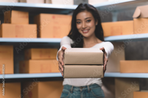 young beautiful woman smiling and happy with thumbs up handle the parcel. Young women packing a parcel order for shipping service to online customer.