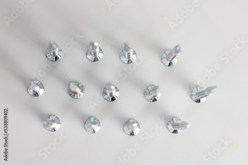 Tapping screws made of steel on gray background, metal screw, iron screw, chrome screw, screws as a background, wood screw, concept industry. copy space for text.