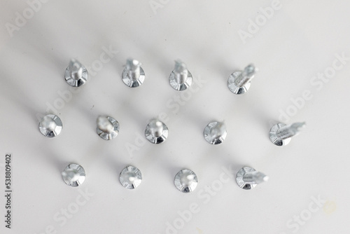 Tapping screws made of steel on gray background, metal screw, iron screw, chrome screw, screws as a background, wood screw, concept industry. copy space for text. © Naknakhone