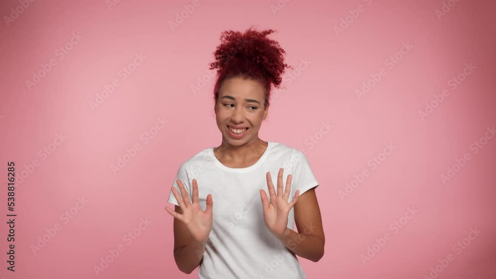 Portrait African American redheaded curly woman need distance showing no stop hands gesture looking camera. Female in white t-shirt express no way, no thanks or I don't need it sign on pink background Portrait African American redheaded curly woman need distance showing no stop hands gesture looking camera. Female in white t-shirt express no way, no thanks or I don't need it sign on pink background