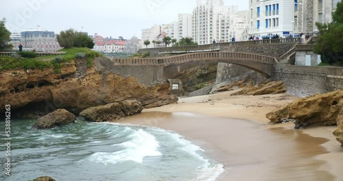 Traveling shot of the seaside resort of Biarritz with a boat passing between the rocks photo