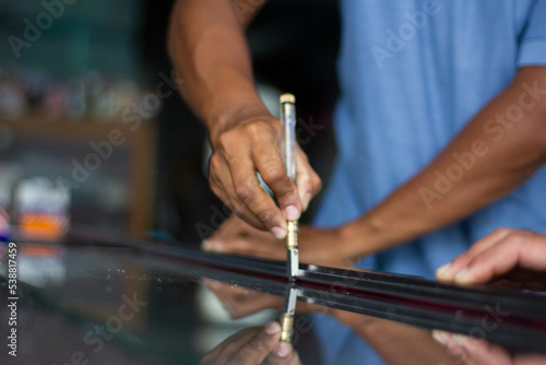 Glass technician uses carbide wheel oil-filled glass cutter  a special type to cut glass for customers.