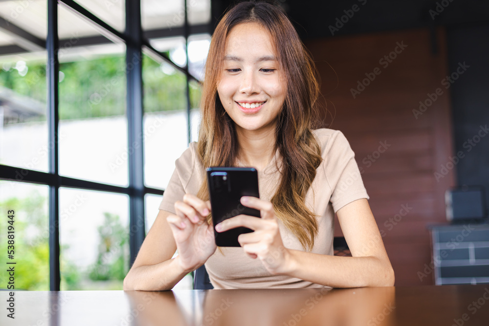 Happy Asian Woman Freelancer working with modern devices, mobile smartphone at cafe. People working with technology and modern devices concept