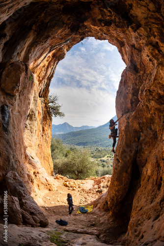 Extreme sport, strong man, rock climber climbs a difficult route.