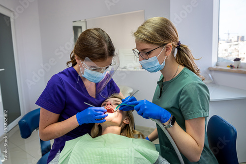 the dentist and his assistant examine the oral cavity and treat the client