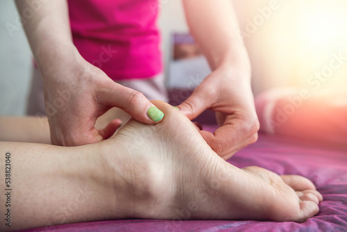 female therapist doing massaging leg female client