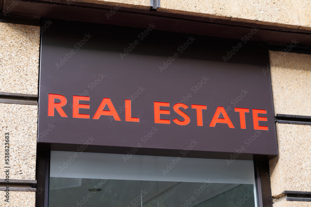 Obraz premium Real Estate store real estate agency office brand text sign on wall facade