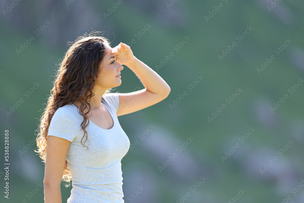 Woman searching with hand on forehead in the mountain Woman searching with hand on forehead in the mountain
