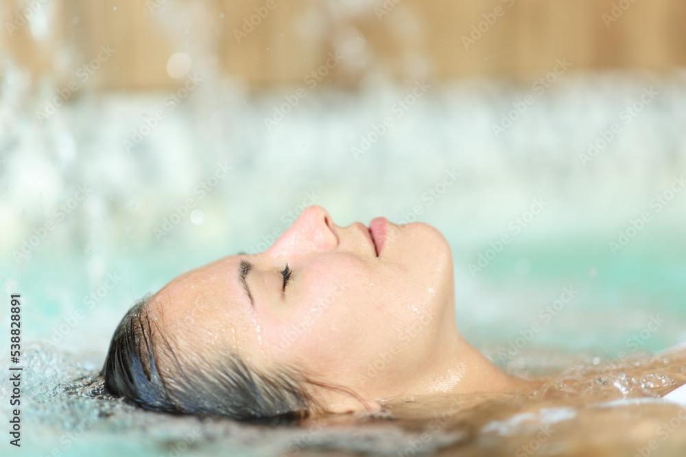 Woman floating and relaxing in a spa pool Woman floating and relaxing in a spa pool