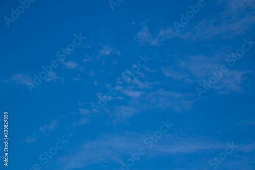 Blue sky with a few clouds background.