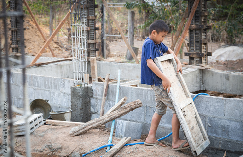 Poor children working at construction site against children labour, Children have to work because of poverty,  World Day Against Child Labour  and trafficking concept. © Tinnakorn