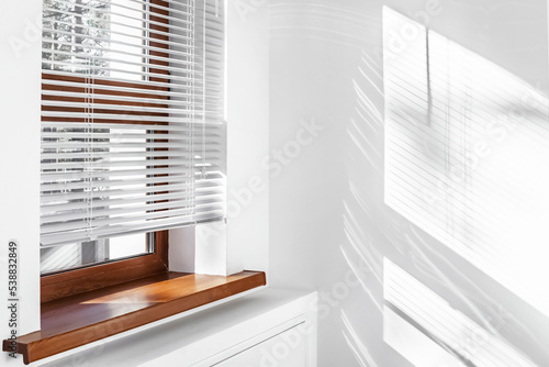 White Venetian blinds with sunlight and shadow. Window blinds. 