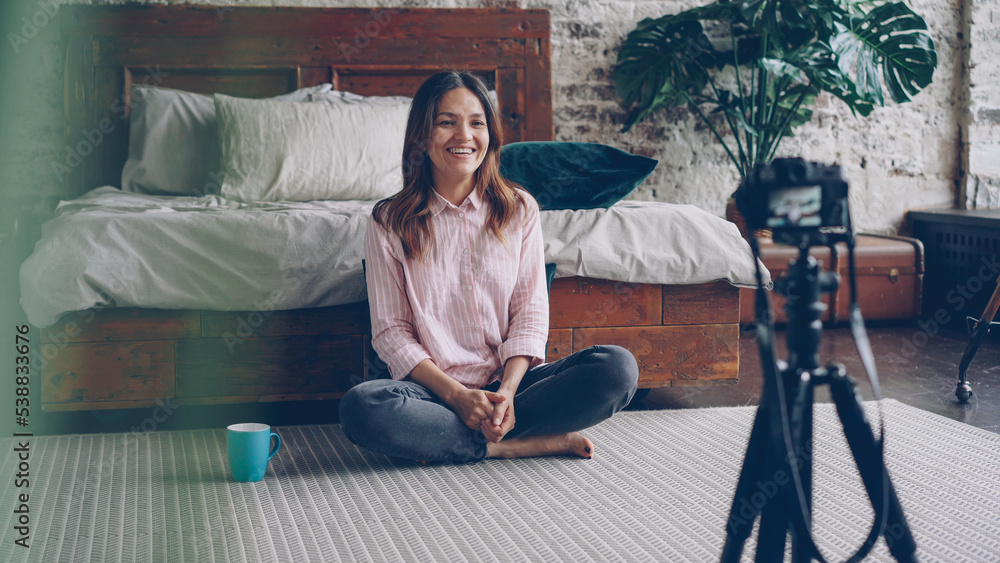 Obraz premium Attractive asian woman famous blogger is recording video for her online vlog using camera, she is talking and gesturing and smiling.
