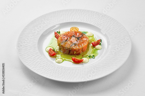 Salmon sous vide with spices in a white plate on a white background. Close-up, selective focus.