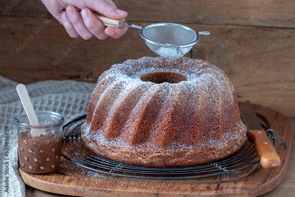 Guglhupf mit Nuss-Nougat-Creme auf einem Kuchengitter Stock Photo ...