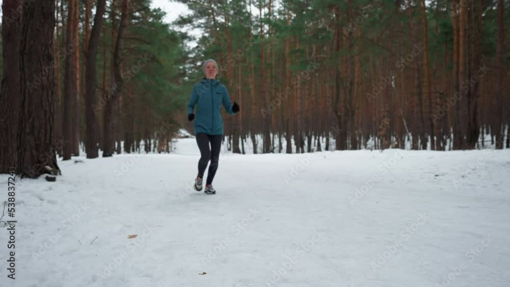 defocus sportswoman running on snow track in forest runner dressed sportswear jogging in winter woman exercising for health and fit defocus sportswoman running on snow track in forest runner dressed sportswear jogging in winter woman exercising for health and fit