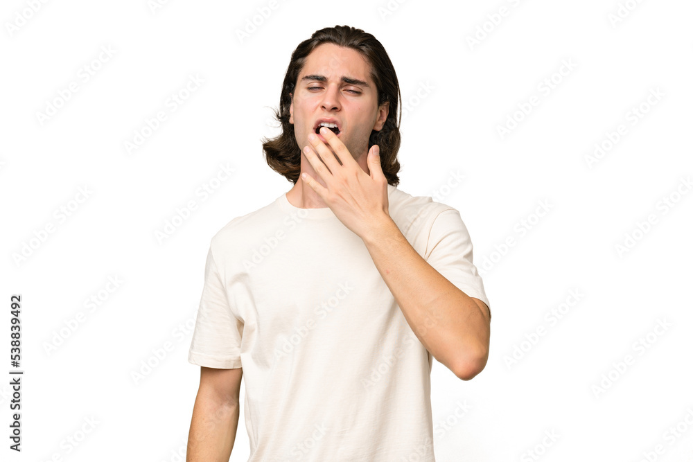 Young caucasian man isolated on green chroma background yawning and covering wide open mouth with hand Young caucasian man isolated on green chroma background yawning and covering wide open mouth with hand