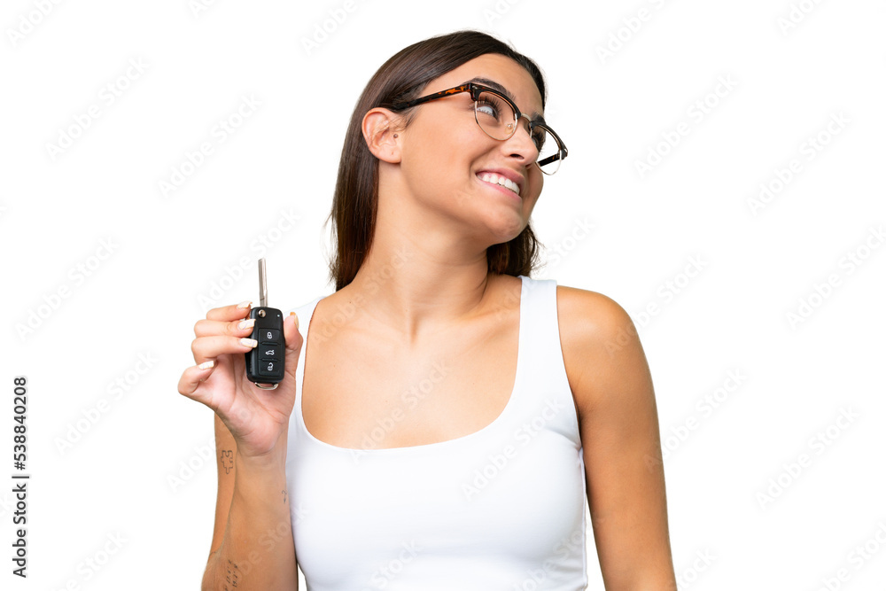 Young caucasian woman holding car keys isolated on green chroma background background looking up while smiling Young caucasian woman holding car keys isolated on green chroma background background looking up while smiling