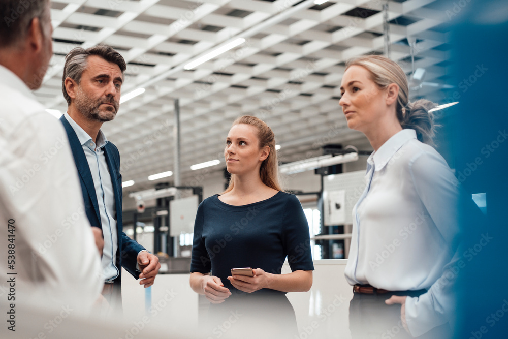 Businessman discussing with colleagues in industry Businessman discussing with colleagues in industry