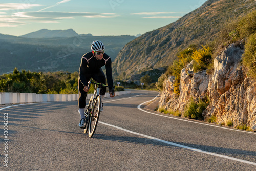 Sportsman cycling on mountain pass in Alicante, Spain photo