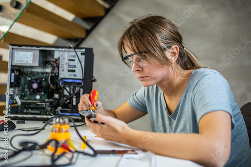 Portrait of a yoing woman repairing desktop computer
Woman wearing protective glasses