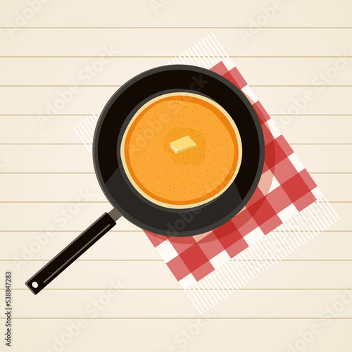 Frying pan with pancakes on white wooden table with red fringed checkered napkin