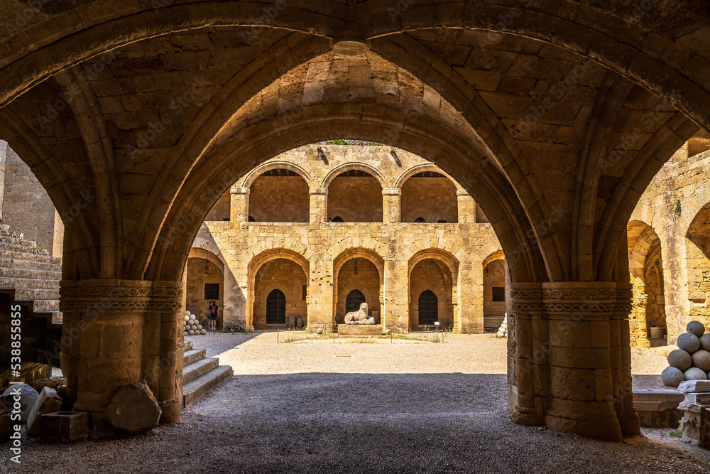 View of an ancient building through stone arches in the old town of Rhodes in Greece