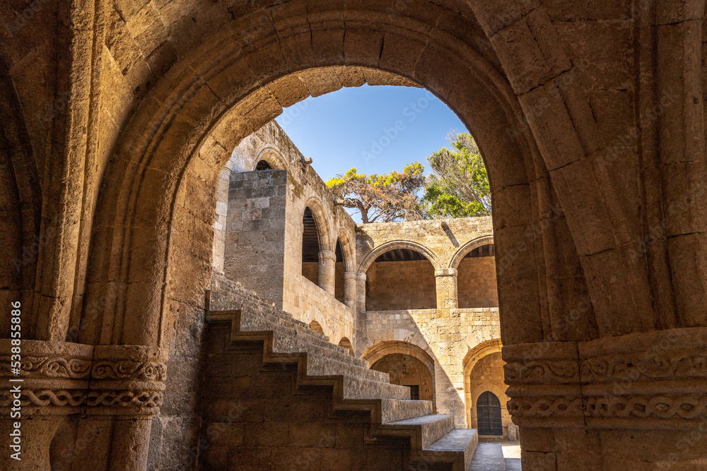 View of an ancient building through stone arches in the old town of Rhodes in Greece