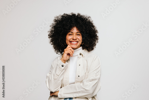 Foto Gorgeous woman with Afro hair smiling happily in a studio