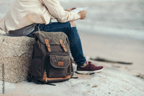 Tourists put their bags on the floor and hold maps to find attractions, restaurants or hotels. backpacker and travel concept.