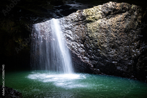 unique waterfall hidden in a cave in the tropical rainforest in springbrook national park in queensland  australia  natural bridge near gold coast