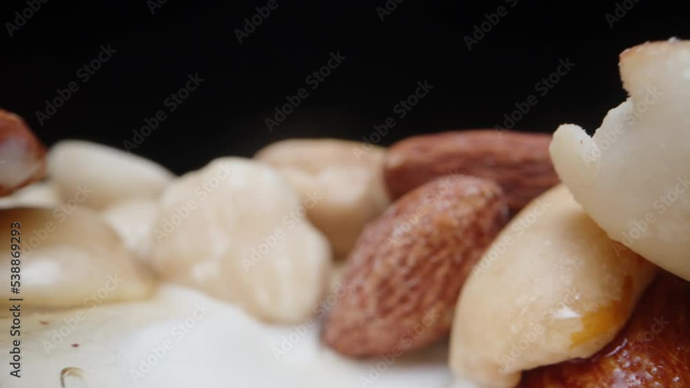 A scattering of nuts with honey on ice cream, the camera slides along them on ice cream, extreme close-up A scattering of nuts with honey on ice cream, the camera slides along them on ice cream, extreme close-up