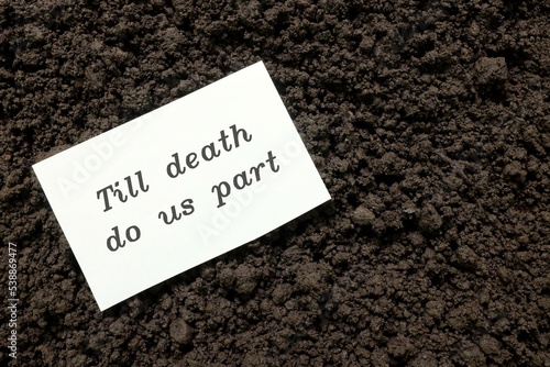 Obraz na płótnie Till death do us part wedding vow concept. Handwritten note on paper on grave soil. w salonie