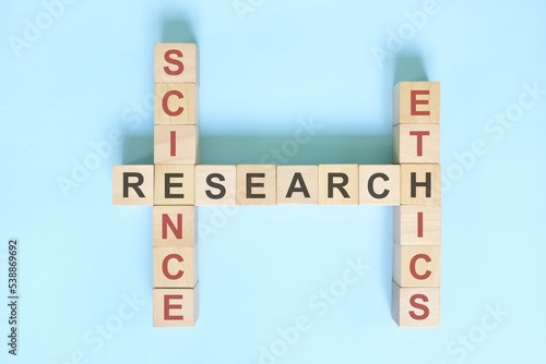 Science research ethics concept. Crossword puzzle flat lay typography in blue background