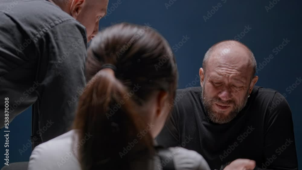 Police detective slams fist on table and shouts at suspected man in handcuffs. Interrogation of criminal. Murderer is afraid of FBI agent's threats and is ready to tell everything Police detective slams fist on table and shouts at suspected man in handcuffs. Interrogation of criminal. Murderer is afraid of FBI agent's threats and is ready to tell everything